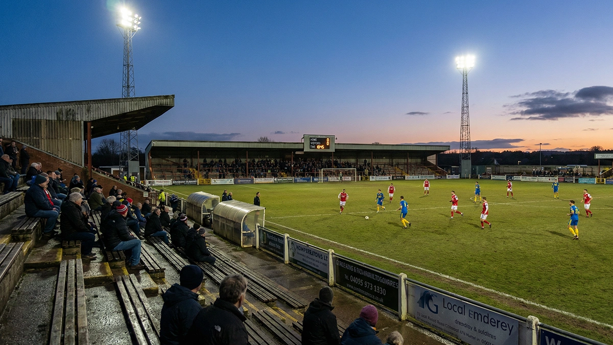 Carnet ouvert avec un tableau de suivi de performance manuscrit et un stylo posé à côté